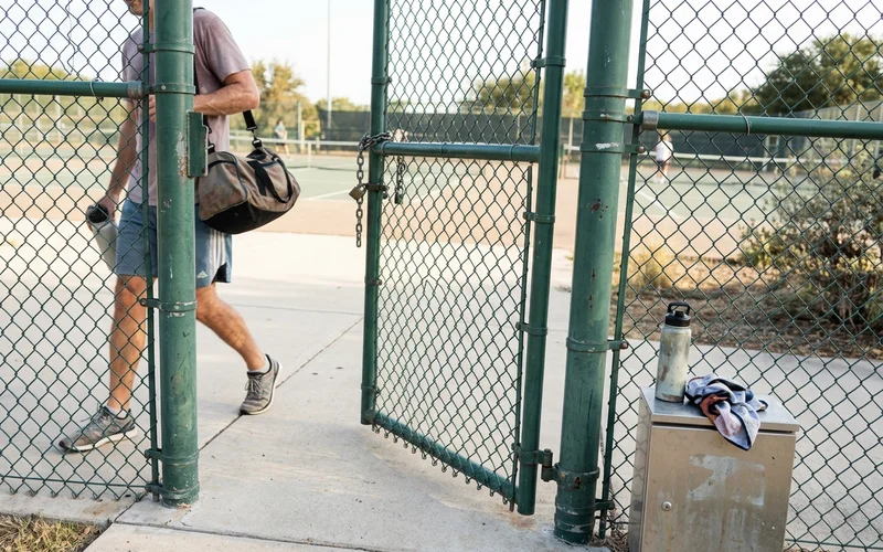 Heavy-duty commercial court fencing and gate detail at a public facility