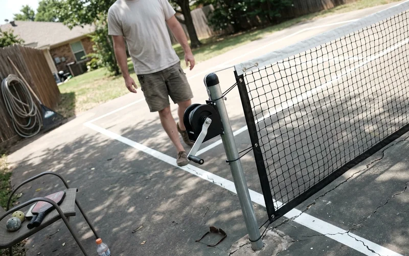 Height-adjustable multi-sport net system installed on a court