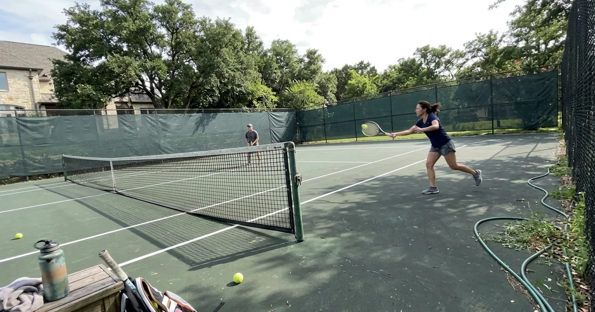 Home tennis court with fresh lines and net on a Texas estate lot