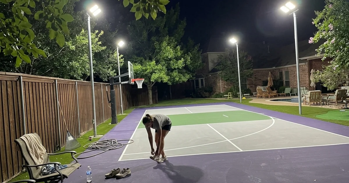 Sport court lit for evening play with LED floodlights on galvanised poles
